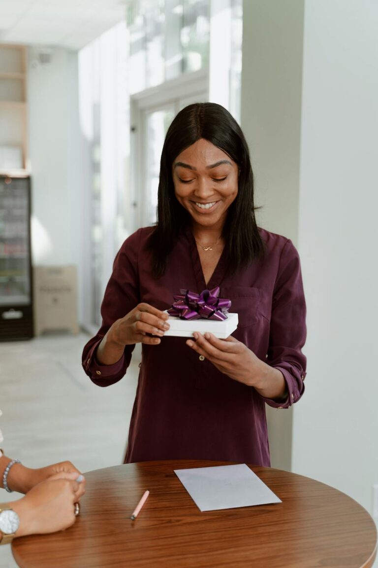 Woman delightedly opening a wrapped present with a smile