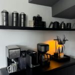 Breville espresso machine on a home kitchen counter with coffee accessories
