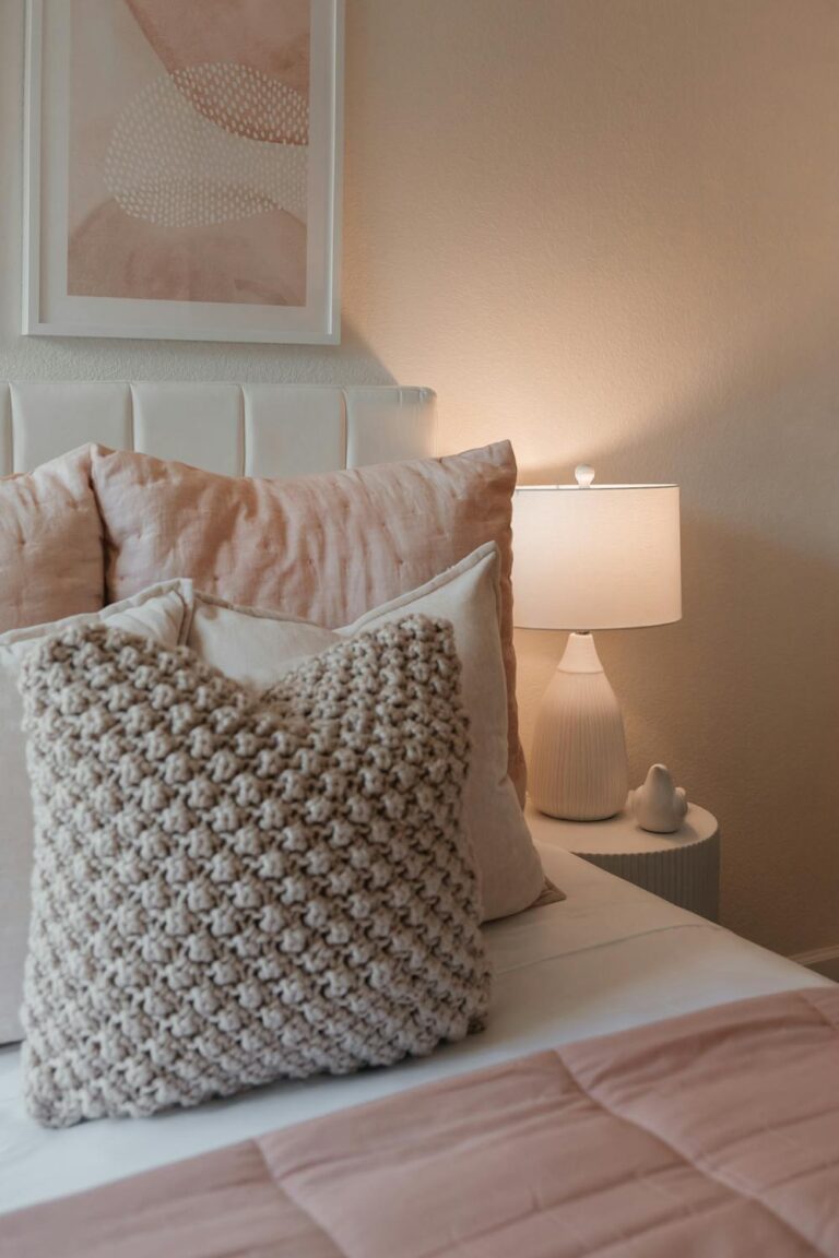 Cozy bedroom with layered soft pillows and warm ambient lighting