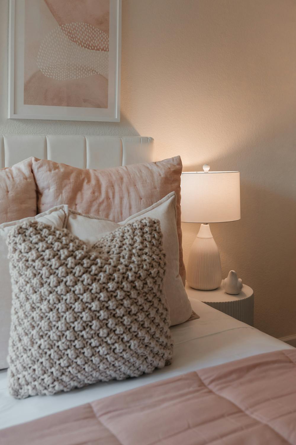 Cozy bedroom with layered soft pillows and warm ambient lighting