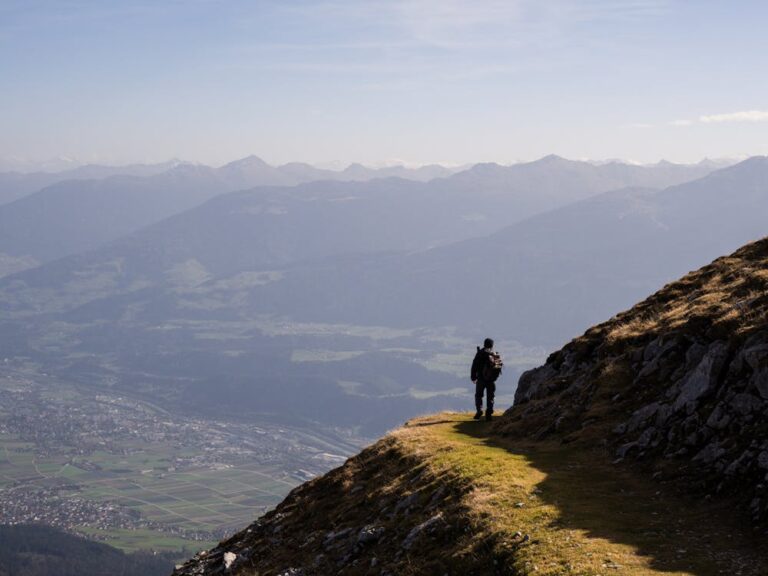 Hiker enjoying a scenic mountain view on a trail -- perfect light for hiking photography