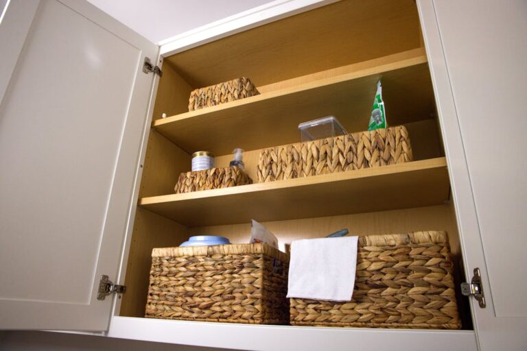 Organized kitchen cabinet with wicker baskets for a clean and tidy home
