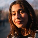 Young woman smiling in natural light outdoor portrait