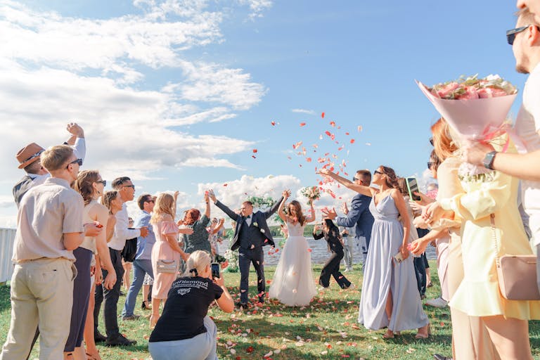 Women in colorful spring wedding guest outfits celebrating outdoors at a joyful garden wedding ceremony