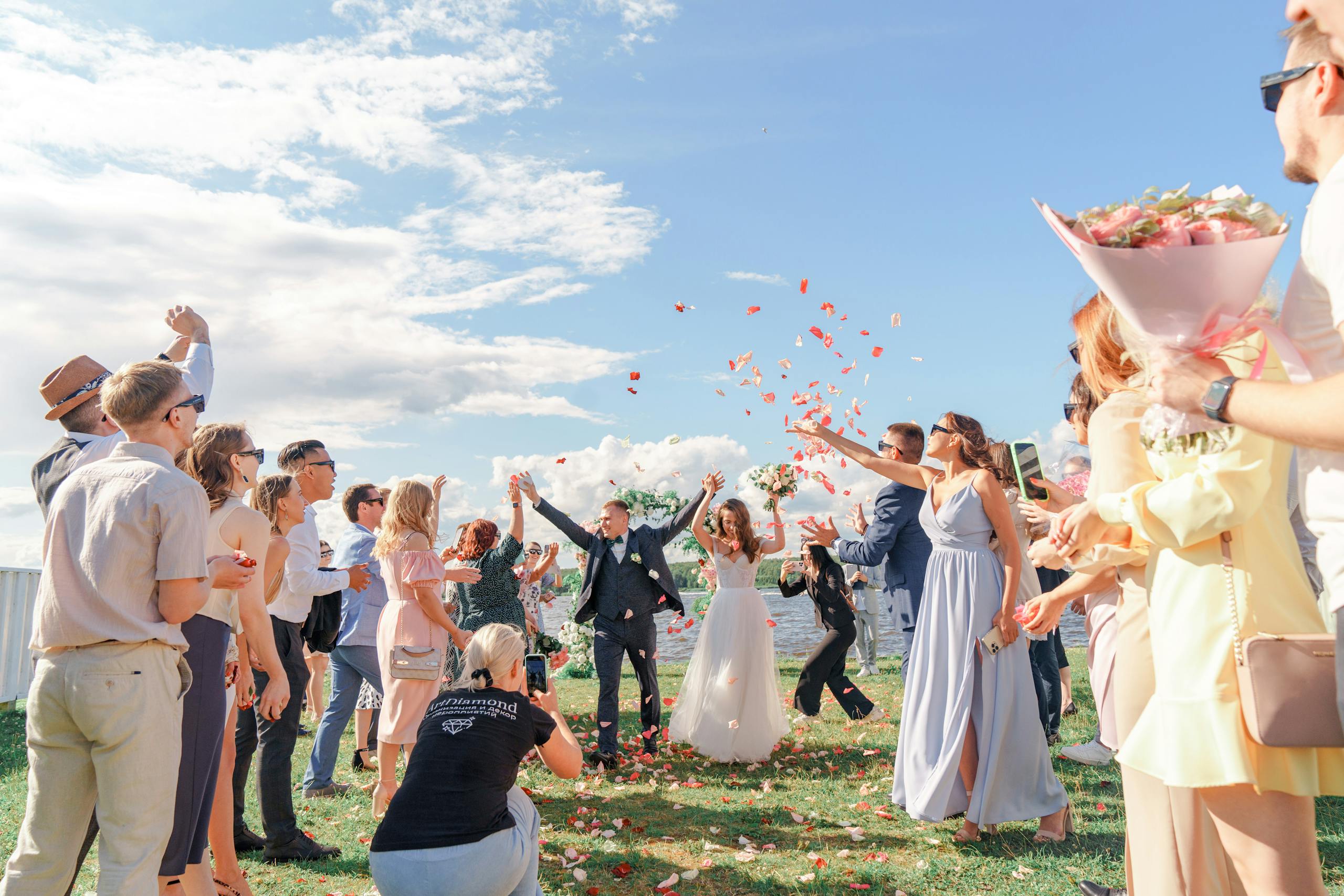 Women in colorful spring wedding guest outfits celebrating outdoors at a joyful garden wedding ceremony