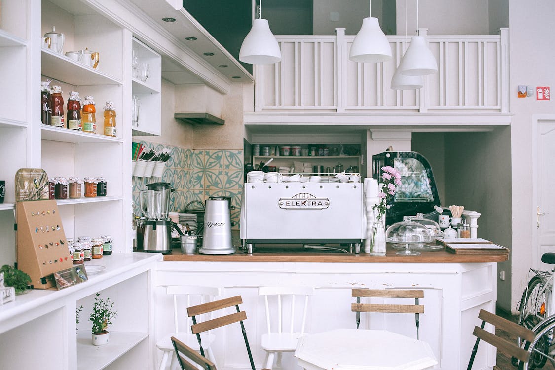 Interior of cozy light cafe counter with coffee machine and white decor