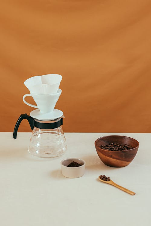 Minimalist home coffee setup with pour-over brewer and fresh coffee beans on a clean countertop