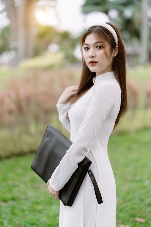 Woman in minimalist white dress standing outdoors in natural light