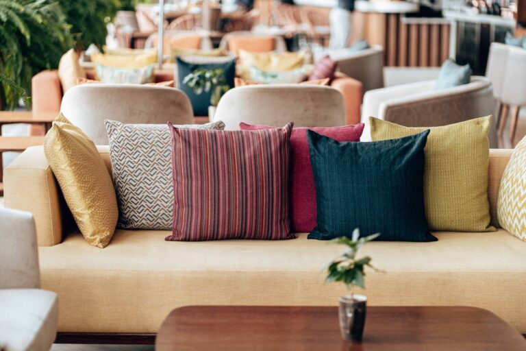 Colorful boho throw pillows styled on a bright couch, the decorative pillow ideas from this list